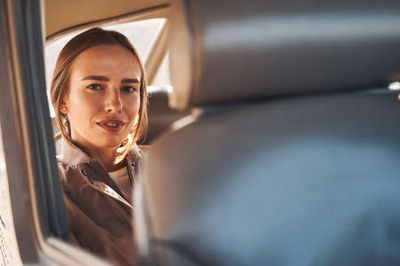 Charming young woman sitting on passenger seat in carの写真素材