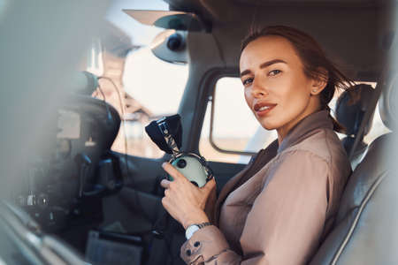 Attractive young woman sitting in aircraft pilot cabinの写真素材