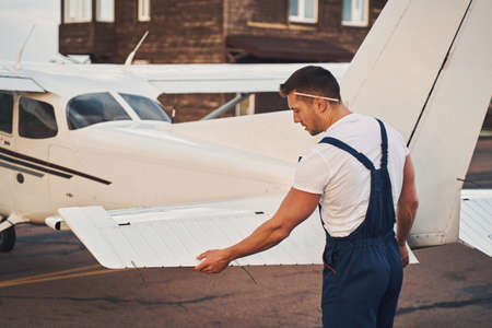 Male worker inspecting aircraft stabilizer at aerodromeの写真素材