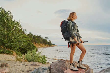 Sportive woman standing on rocks at riversideの写真素材