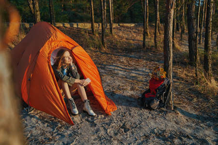 Calm woman inside tent is admiring sunsetの写真素材