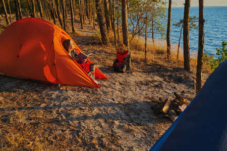Woman exposing her face to sun from tent