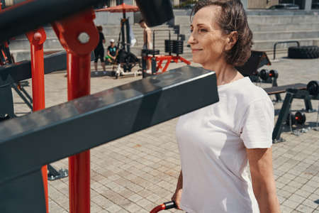 Smiling active woman doing workout in open air