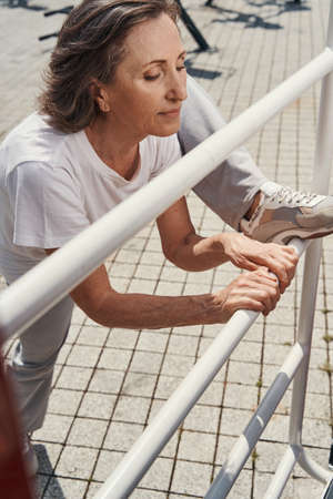 Relaxed mature slim woman exercising in open airの写真素材