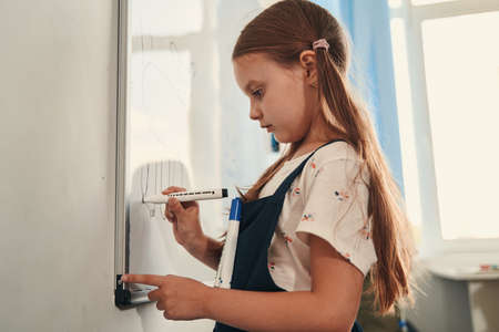 Child adding important details to her pictureの写真素材