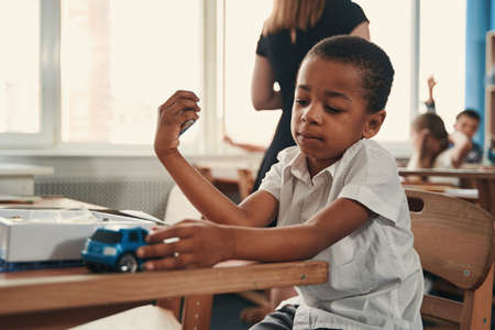 Calm kid with his favorite toy at the lessonの写真素材