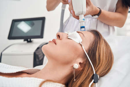 Attractive lady relaxing during reguvenation procedure in clinicの写真素材