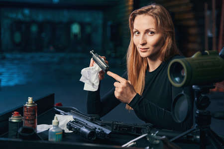 Professional female shooter cleaning her disassembled firearmの写真素材