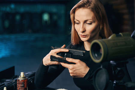 Focused serious female shooter holding a handgun partの写真素材