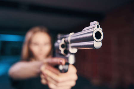 Experienced woman shooter holding a pistol with both handsの写真素材