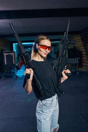 Beautiful tranquil woman in protective eyewear showing her carbines