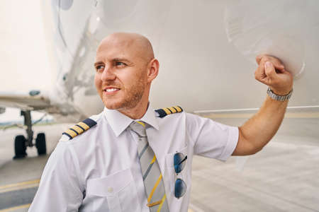 Airline captain standing by a landed airliner