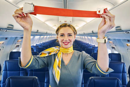 Air hostess performing a pre-flight safety demonstration before the take-off