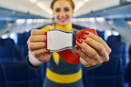 Female flight attendant conducting the pre-flight safety demonstrationの写真素材