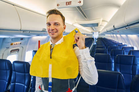 Joyous steward wearing a life vest aboard the aircraft