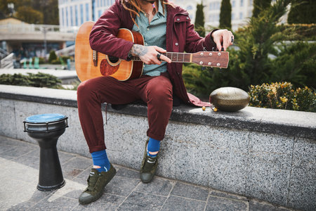 Serious male person holding his favorite guitar