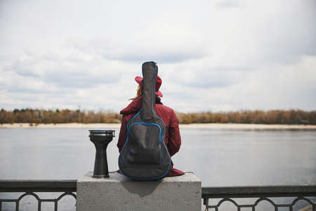 Inspired street musician looking at the river