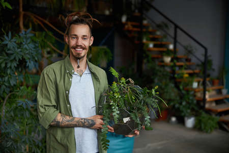 Cheerful young man holding geometric glass terrariumの写真素材
