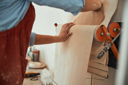 Female ceramist using linen cloth in pottery workshopの写真素材
