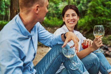 Happy man and woman with glasses of drinks outdoorsの写真素材
