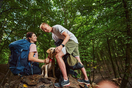 Joyful active young people going walking with dog
