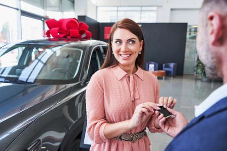 Unrecognized man presenting new car to his wifeの写真素材