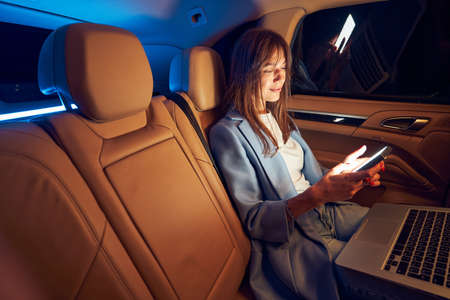 Businesswoman using smartphone and laptop in careの写真素材