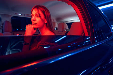 Travel woman sitting in automobile at nightの写真素材