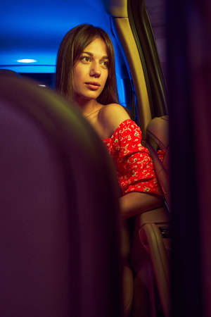 Serious woman looking out opened car window