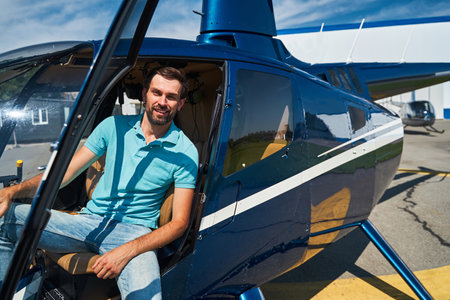 Happy male pilot posing for camera before helicopter flightの写真素材