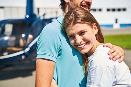 Joyous romantic lady hugging man at heliportの写真素材