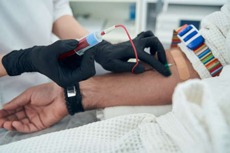 Medical laboratory worker taking blood sample from patientの写真素材