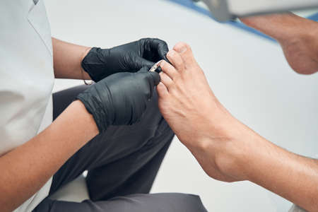 Pedicure master cutting man toenails in cosmetology salonの写真素材