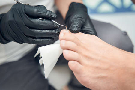 Pedicure master hands doing pedicure for manの写真素材
