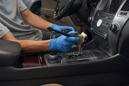 Automotive industry worker carefully detailing car interiorの写真素材