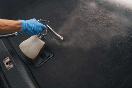 Hand of professional male worker doing cleaning in car interiorの写真素材