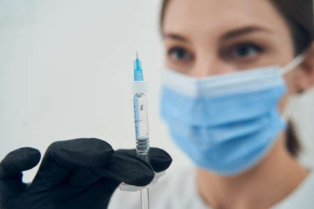 Female doctor cosmetologist holding syringe for procedureの写真素材