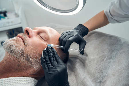 Man receiving anti-aging injection in cosmetology salonの写真素材