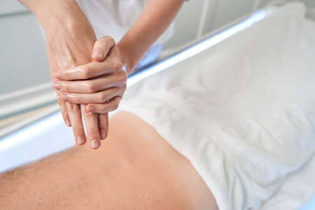 Masseuse rubbing hands with massage oil before procedureの写真素材