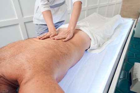 Man receiving professional back massage in spa salonの写真素材
