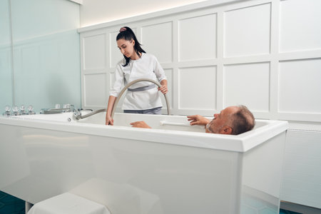Man taking revitalizing bath in spa salonの写真素材