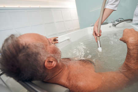 Man having hydromassage procedure at wellness spa centerの写真素材