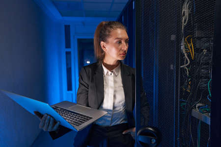 Pretty woman working in internet server roomの写真素材