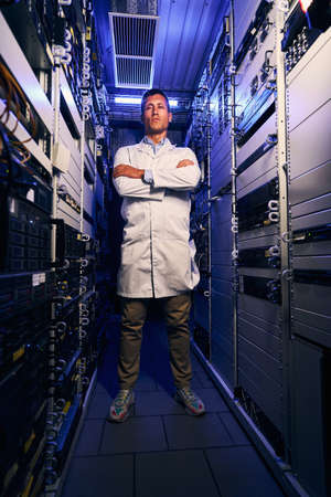 Serene IT technician standing alone in server roomの写真素材