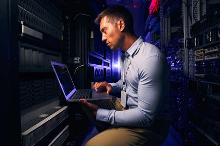 Serious focused system administrator checking data center equipment