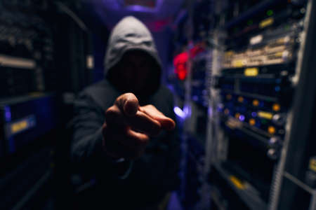 Man dressed in hoodie making hand gesture
