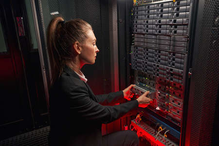 Beautiful female engineer replacing hard drive in serverの写真素材