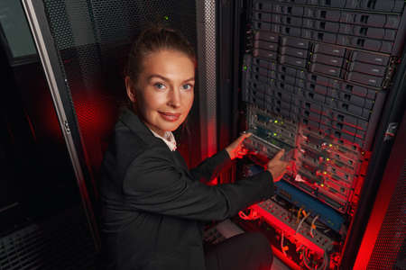 Computer technician working with backup server in racksの写真素材