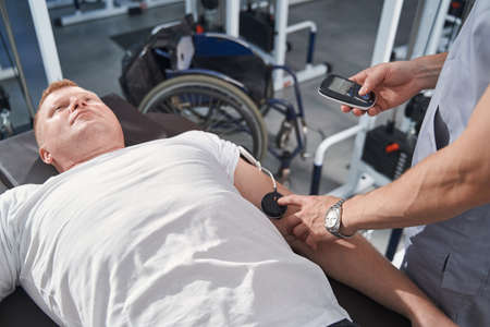 Close up massage of man shoulder with electrostimulator. Myostimulation
