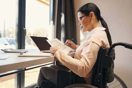Serious female with disability doing work from home
